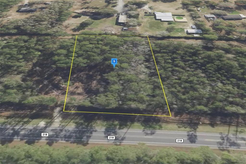 An aerial view shows a rectangular, wooded plot of land bordering a paved road — 4739 COUNTY ROAD 218 ROAD, MIDDLEBURG, FL