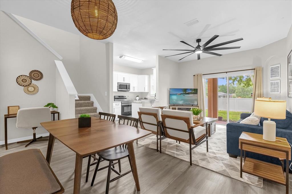 A two-story tan stucco townhouse with brown shutters, a tiled roof, and palm trees — 2020 CALABRIA AVENUE, DAVENPORT, FL