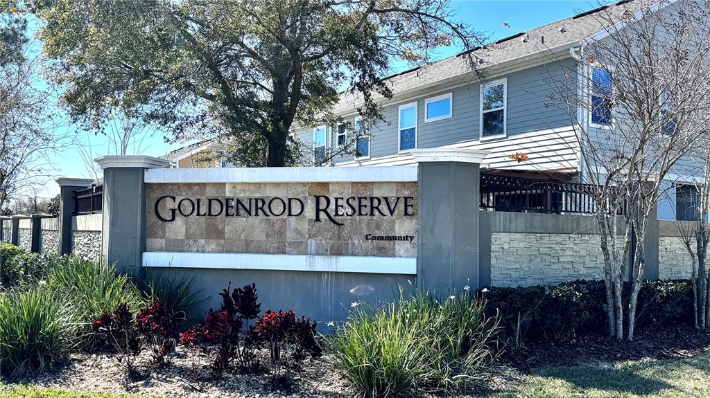 A stone monument sign for Goldenrod Reserve Community stands in front of a multi-story building — 4420 GUMBO LIMBO DRIVE, ORLANDO, FL