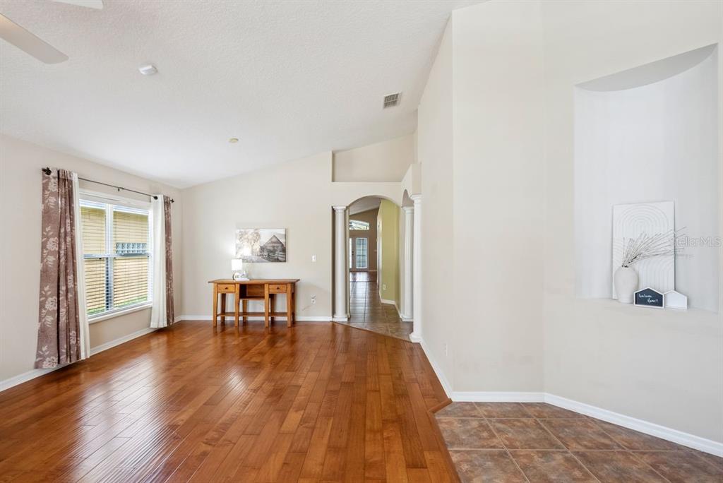 A living room with hardwood floors, a recessed wall niche, and an arched entryway — 5345 LOS PALMA VISTA DRIVE, ORLANDO, FL