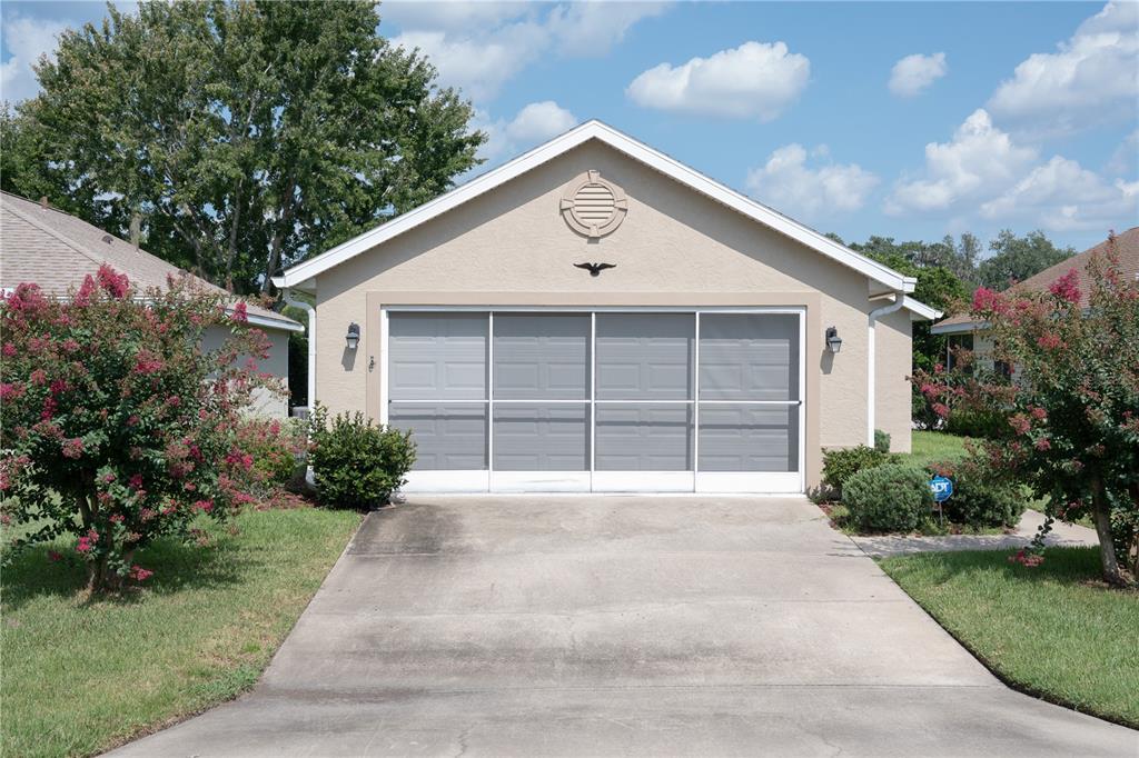 A beige detached garage with a sliding screen door and a concrete driveway — 1913 NW 50TH CIRCLE, OCALA, FL