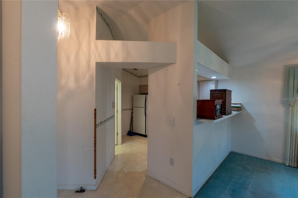 A view from a carpeted room looking through a doorway into a kitchen area — 1913 NW 50TH CIRCLE, OCALA, FL