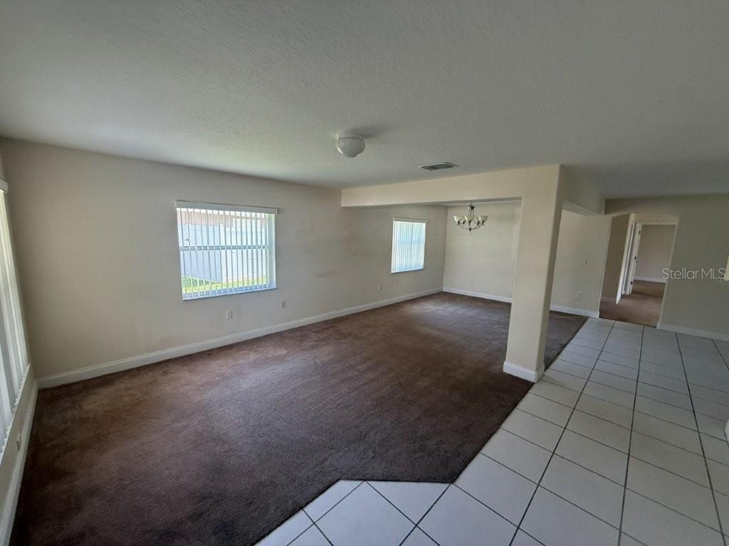A living room with brown carpeting, white walls, and a tiled entryway — 960 CHASE COURT, WINTER GARDEN, FL