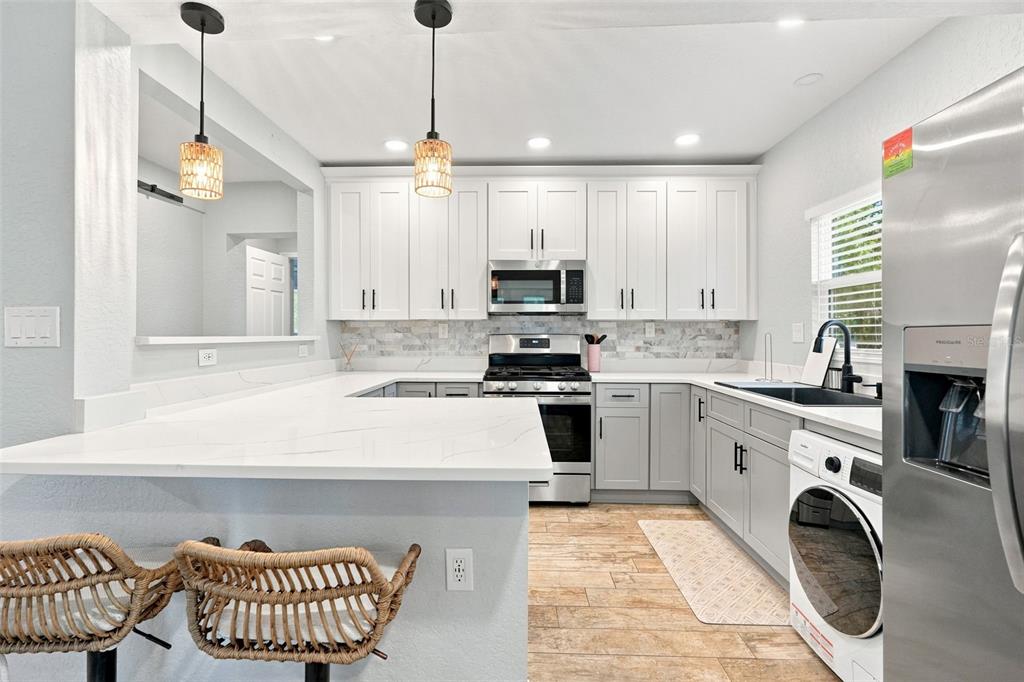A living room features a brick fireplace, two red armchairs, and glass doors to outside — 5421 GAY STREET, WEEKI WACHEE, FL