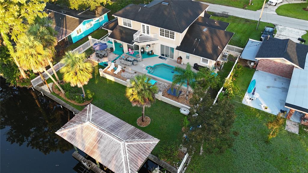An aerial view shows a two-story house with a pool, patio, and private boat dock — 556 NW FERN DRIVE, CRYSTAL RIVER, FL