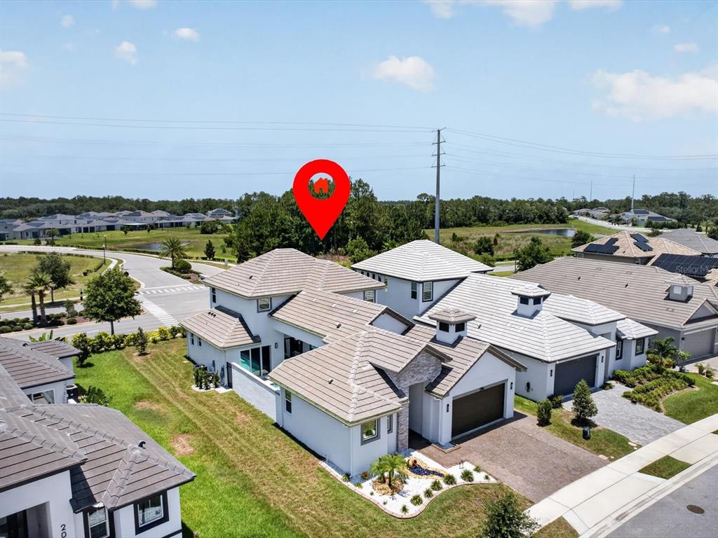 An aerial view shows a modern two-story house with a tiled roof and a red pin — 196 HAMPTON LOOP, DAVENPORT, FL