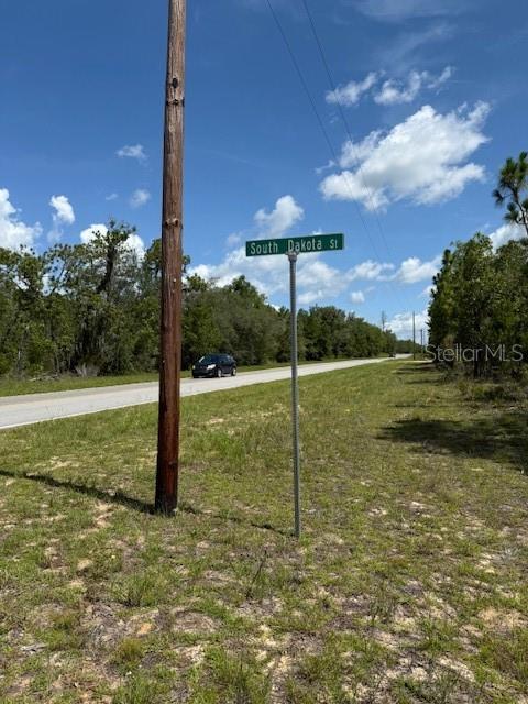 A street sign for South Dakota St stands beside a paved road near a utility pole — 117 S DAKOTA STREET, HAWTHORNE, FL