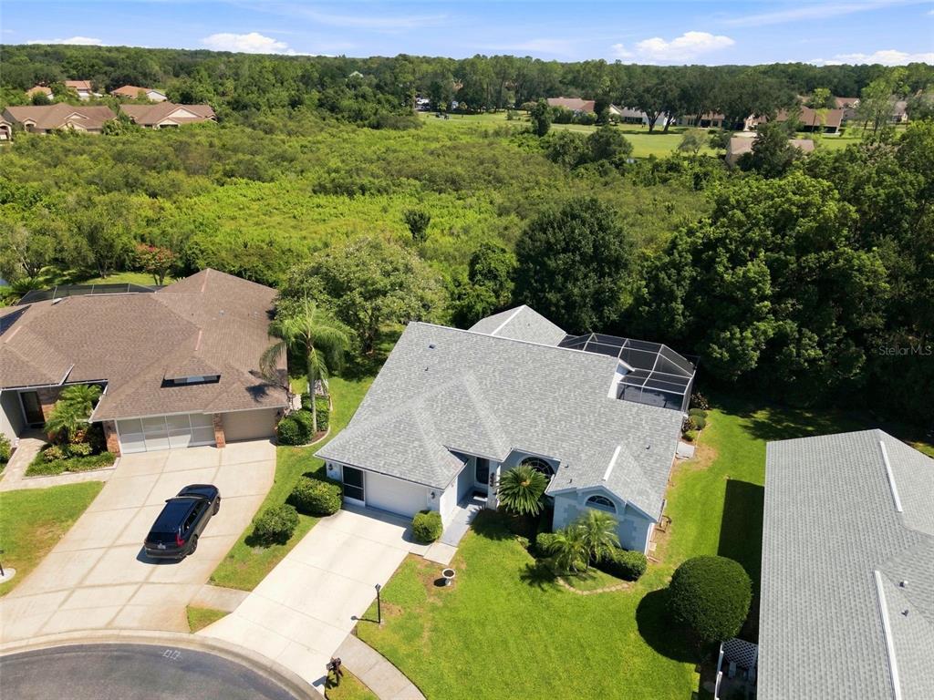 An aerial view shows a suburban house with a gray roof and a screened-in patio — 9423 SUMMERBREEZE TERRACE, NEW PORT RICHEY, FL