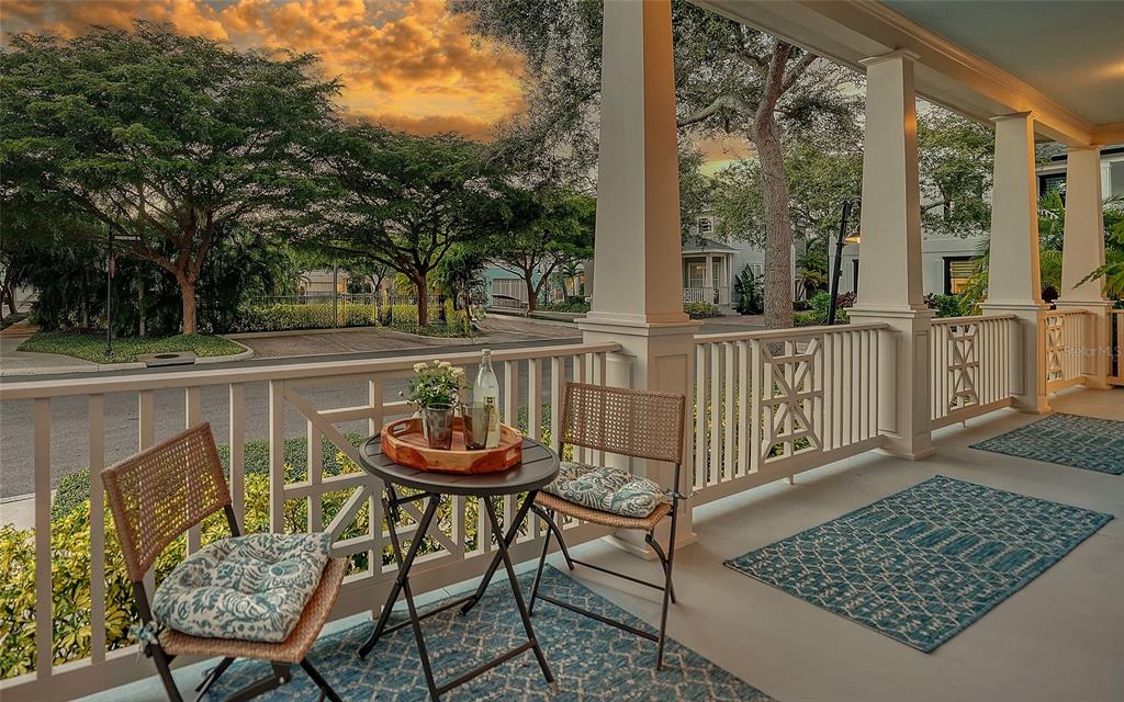 A covered porch features a small table with two chairs and blue patterned area rugs — 1775 STAPLETON STREET, SARASOTA, FL
