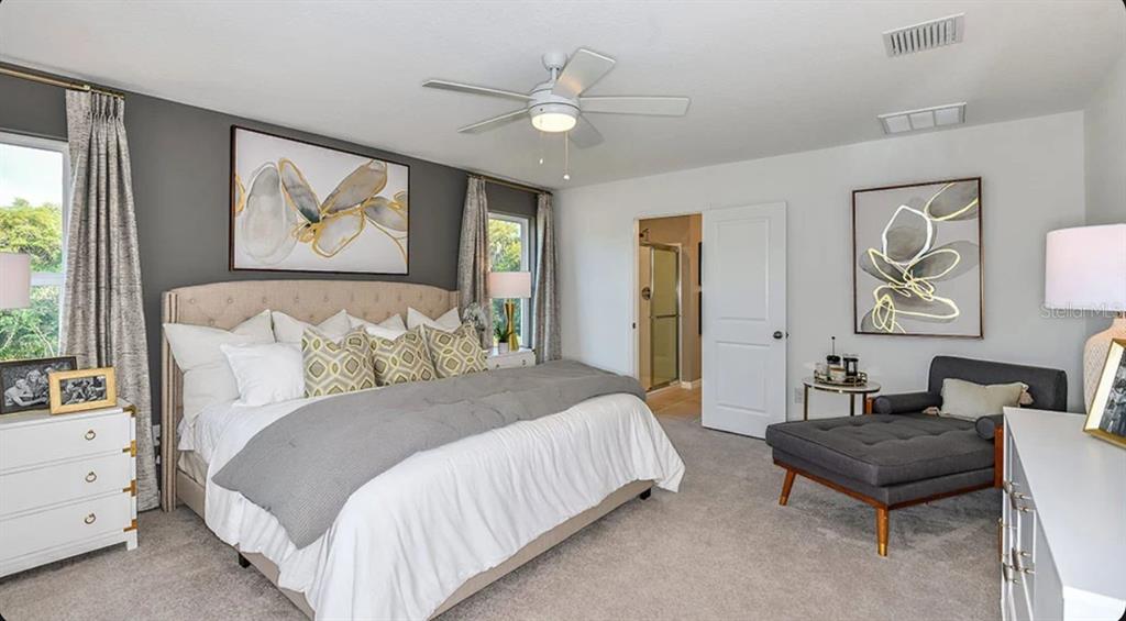 A dining room features a wooden table, modern chandelier, abstract wall art, and sliding glass doors — 13819 SHELLMORE AVENUE, PALMETTO, FL