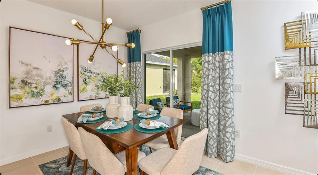 An open-concept living room and kitchen featuring a sectional sofa, teal accents, and large windows — 13819 SHELLMORE AVENUE, PALMETTO, FL