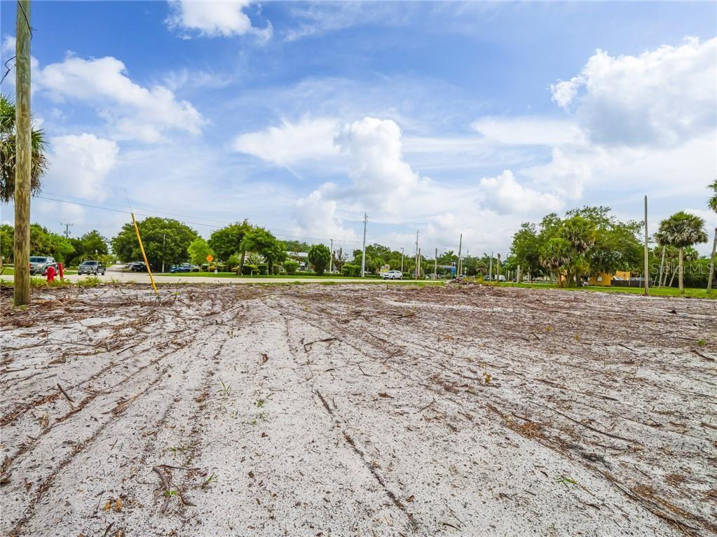 A vacant, sandy lot with tire tracks and scattered debris under a blue sky — 445 OLD DIXIE HIGHWAY, VERO BEACH, FL