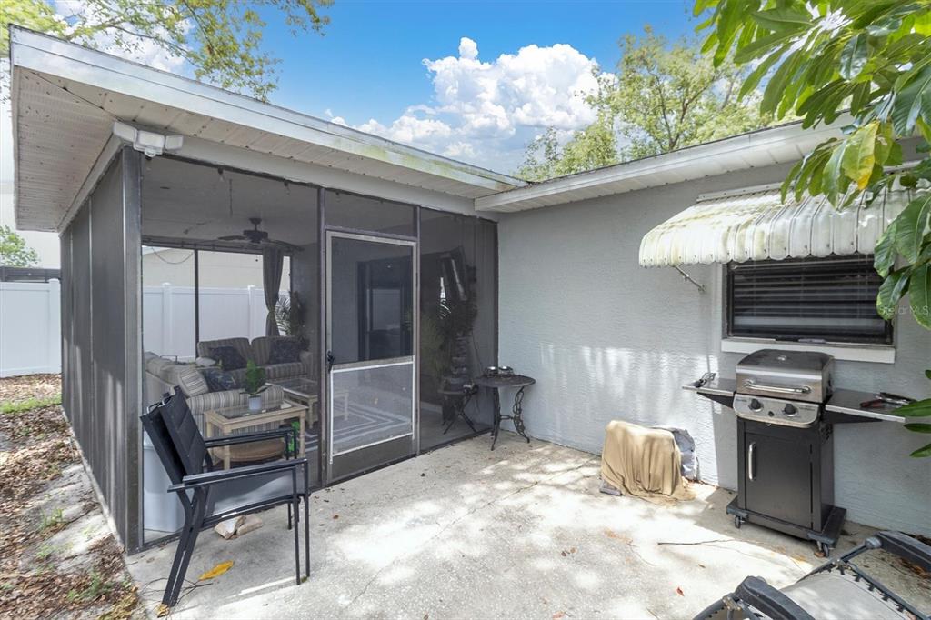 A bright entryway features gray wood-look flooring, a white front door, and two round mirrors — 8038 BUTTONBALL LANE, PORT RICHEY, FL