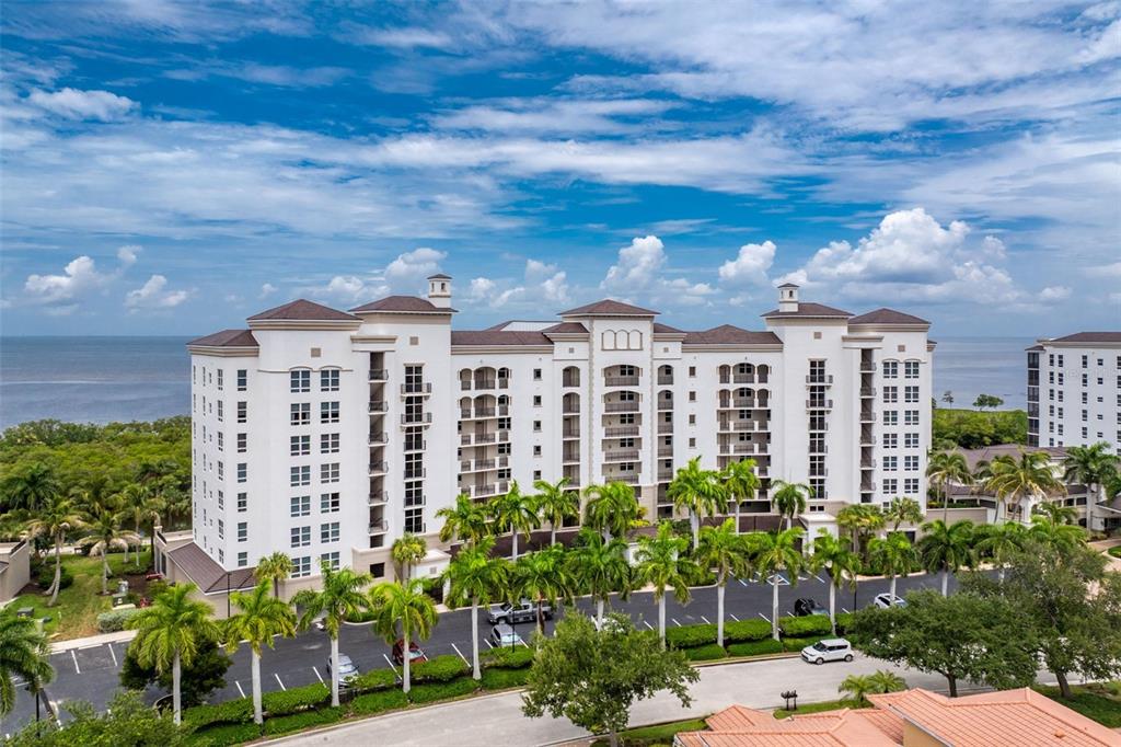 A screened-in balcony features tile flooring, ceiling fans, and a dining set overlooking the water — 3313 SUNSET KEY CIR UNIT 701, PUNTA GORDA, FL