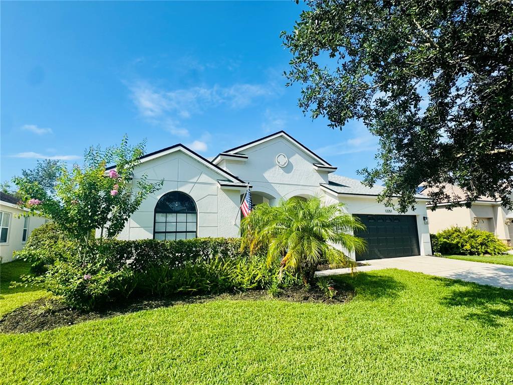 A dining room with a white table, blue chairs, and tile flooring near an entryway — 12251 23RD STREET E, PARRISH, FL