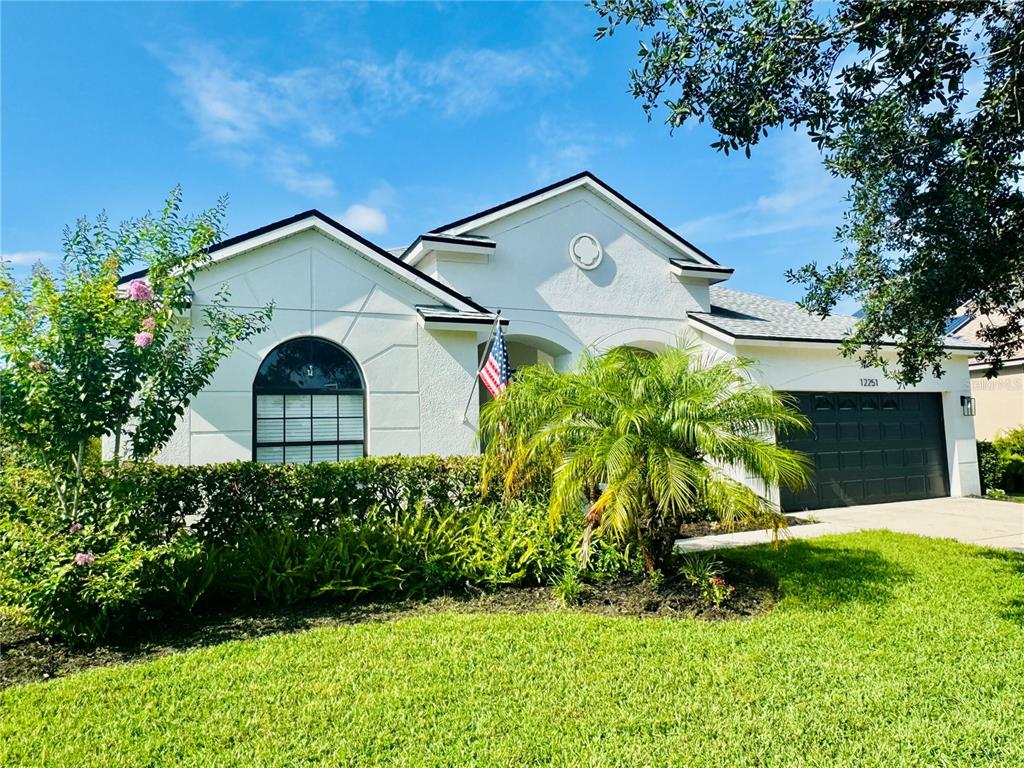 A bright dining area with tile floors, a chandelier, and an adjacent entryway with door — 12251 23RD STREET E, PARRISH, FL