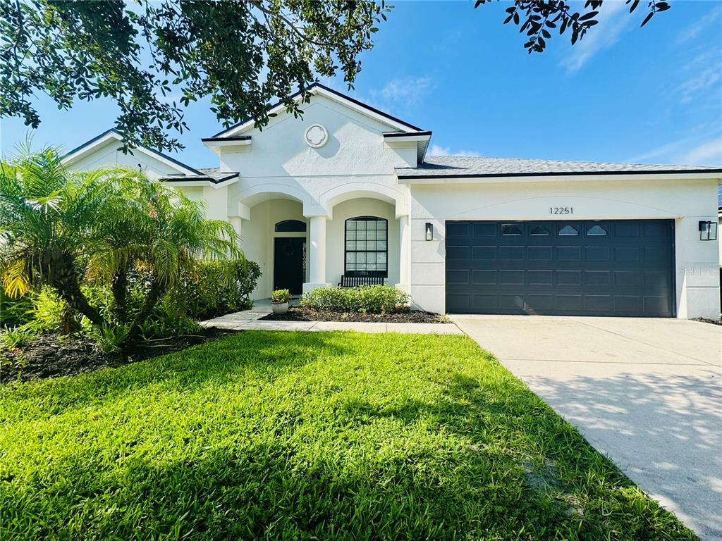 A kitchen features wood cabinets, granite countertops, stainless steel appliances, and a tile backsplash — 12251 23RD STREET E, PARRISH, FL