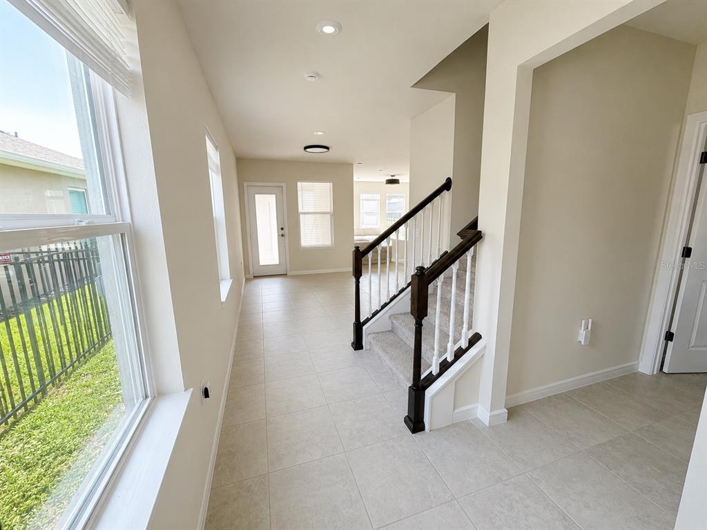 An interior view shows a tiled entryway with a staircase and a glass door — 4083 FEATHER TREE DRIVE, APOPKA, FL