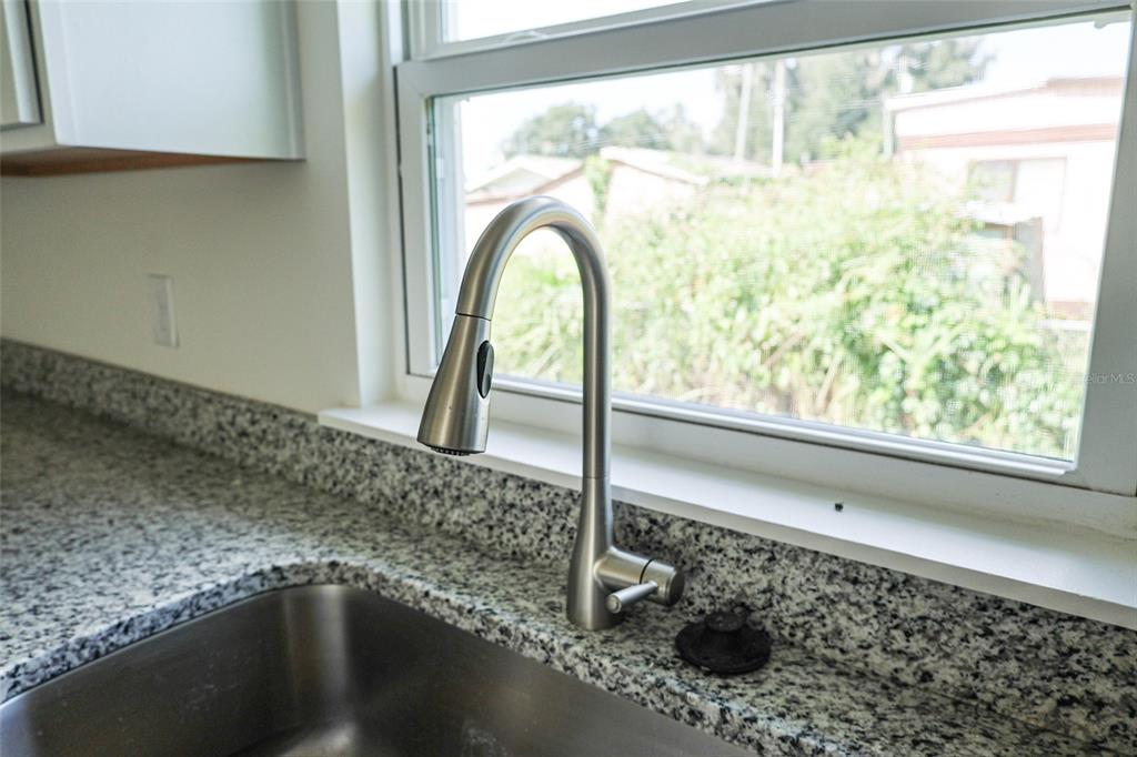 A kitchen with white cabinets, stainless steel appliances, and granite countertops — 79 W CENTRAL AVENUE, WEBSTER, FL