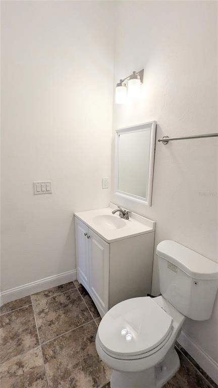 A small bathroom features a white vanity with a sink, a mirror, and a toilet — 9060 MOONLIT MEADOWS LOOP, RIVERVIEW, FL