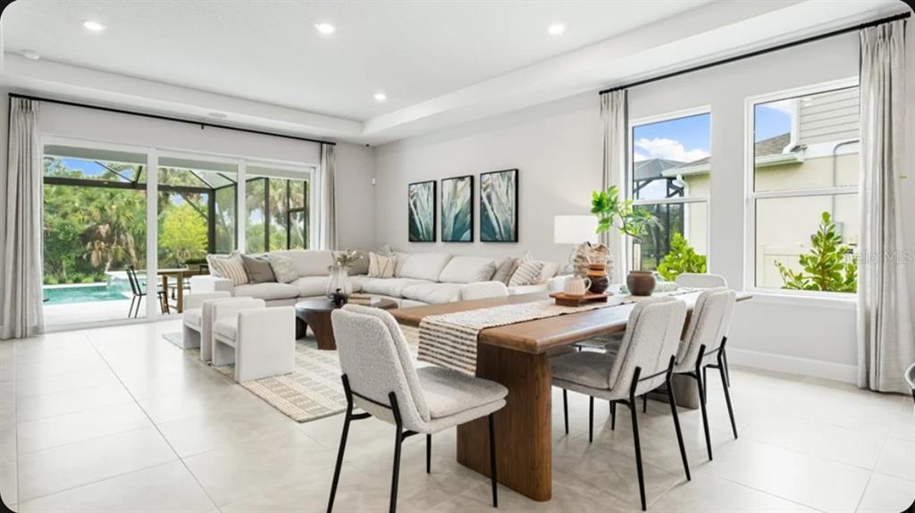 A living room features a green accent wall, a large sectional sofa, and sliding glass doors — 725 SKY SHADE DRIVE, APOLLO BEACH, FL