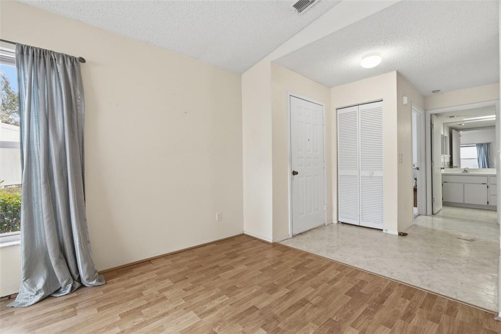 An empty dining room with wood-look flooring, a chandelier, and a sliding glass door — 3960 SAILMAKER LANE, HOLIDAY, FL