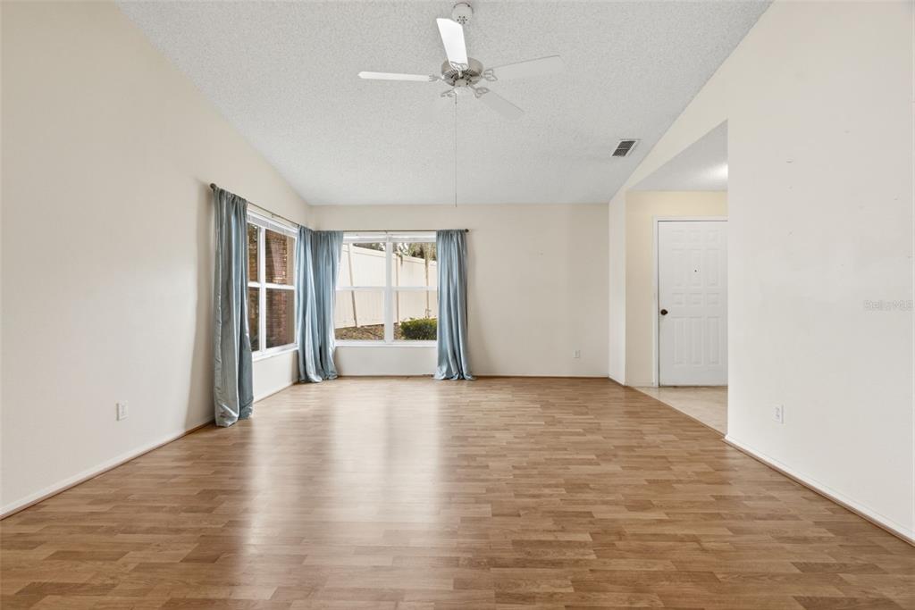 An interior room with wood-look flooring, a white door, a closet, and an adjacent bathroom — 3960 SAILMAKER LANE, HOLIDAY, FL