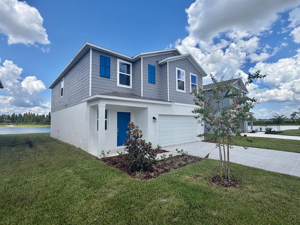 A two-story house with gray siding, a white stucco base, and a blue front door — 6213 BOTTICELLA BOULEVARD, WINTER HAVEN, FL