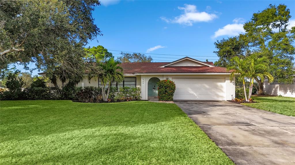 A single-story house with a white exterior, red roof, and a large front lawn — 433 WHITFIELD AVENUE, SARASOTA, FL