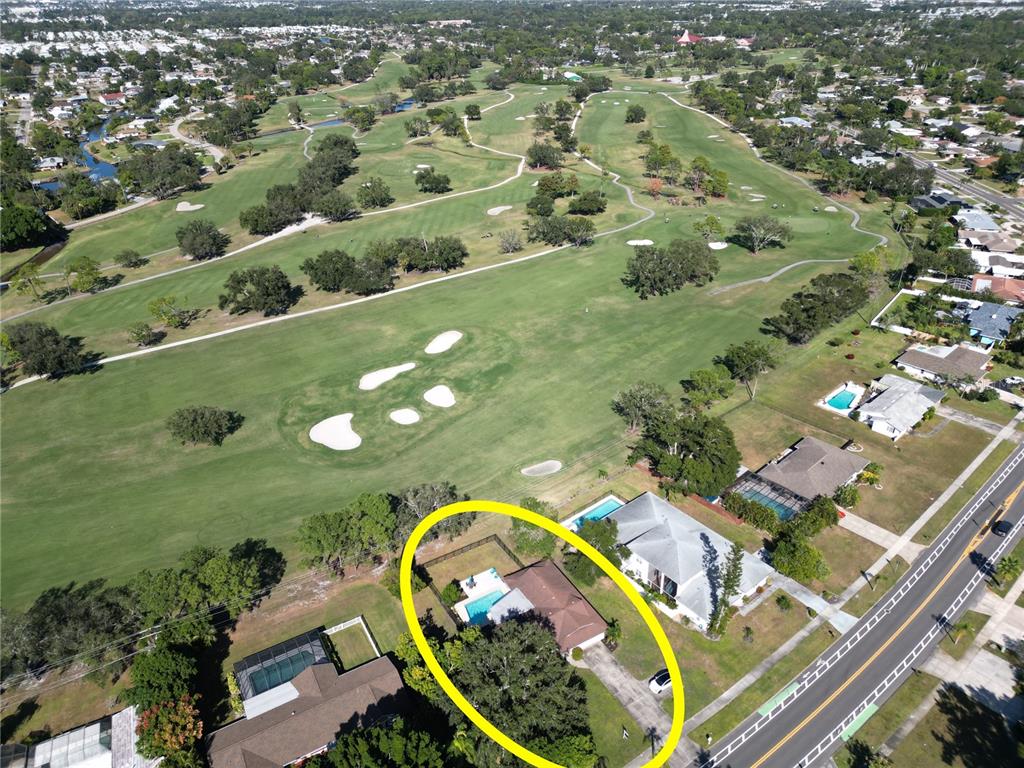 An aerial view shows a single-story house with a pool located next to a golf course — 433 WHITFIELD AVENUE, SARASOTA, FL