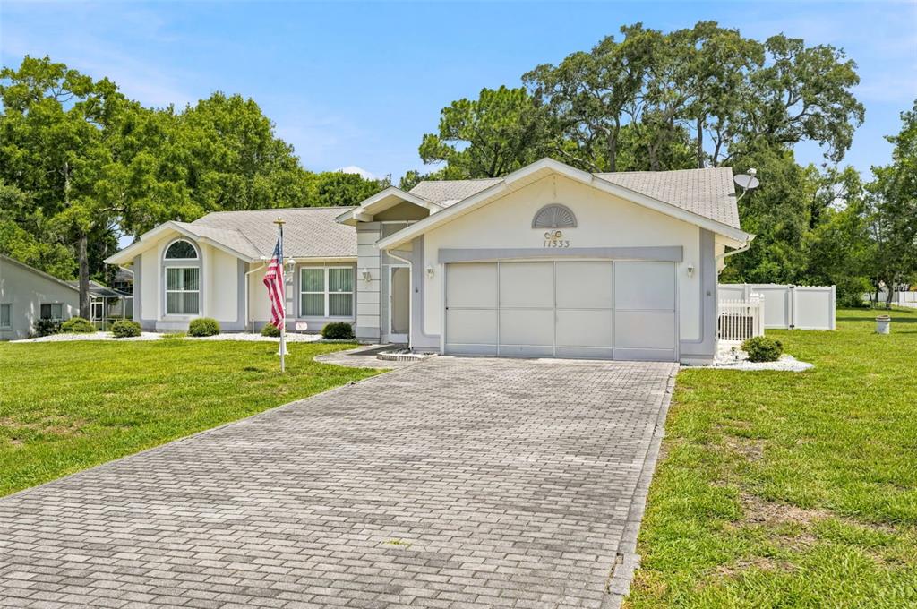 A single-story house with a paved driveway, a two-car garage, and a front yard — 11333 SILVERWOOD COURT, SPRING HILL, FL