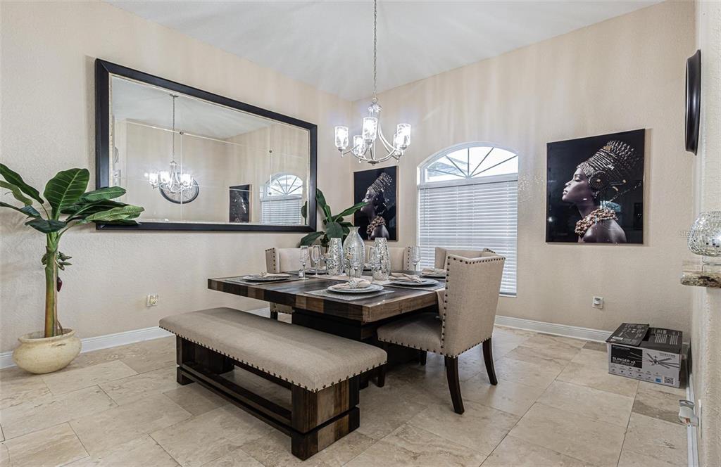 A dining room features a wooden table with a bench, upholstered chairs, and a large mirror — 13102 DONE GROVEN DRIVE, DOVER, FL