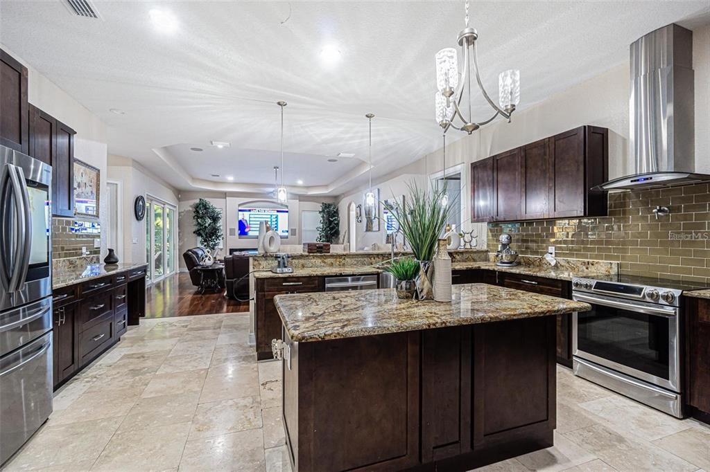 A kitchen with dark wood cabinets, granite countertops, stainless steel appliances, and tile flooring — 13102 DONE GROVEN DRIVE, DOVER, FL