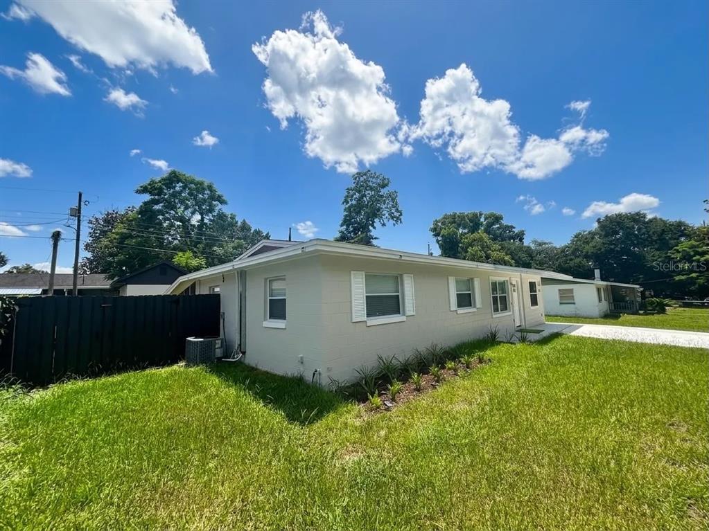 A light-colored, single-story house with a flat roof sits on a grassy lot — 1532 E VOTAW ROAD, APOPKA, FL