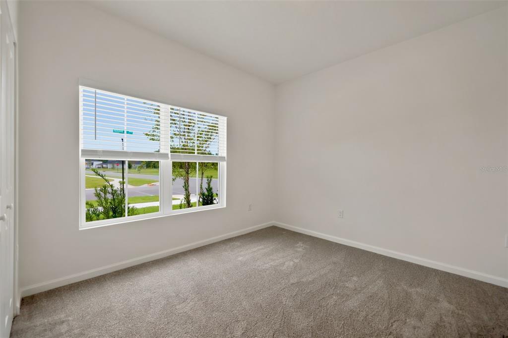 An empty bedroom features gray carpeting, white walls, and a window with white blinds — 3778 HOLSTEIN WAY, GREEN COVE SPRINGS, FL