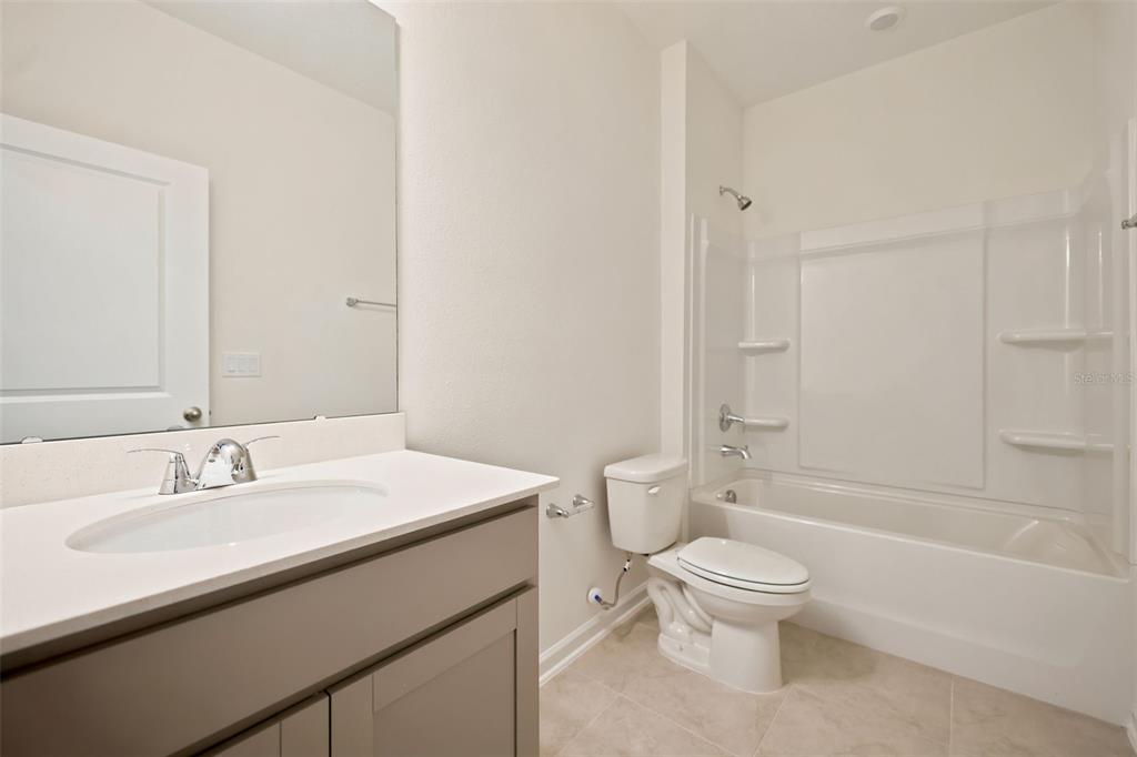 A bathroom features a gray vanity with a white countertop, a toilet, and a tub-shower — 3778 HOLSTEIN WAY, GREEN COVE SPRINGS, FL