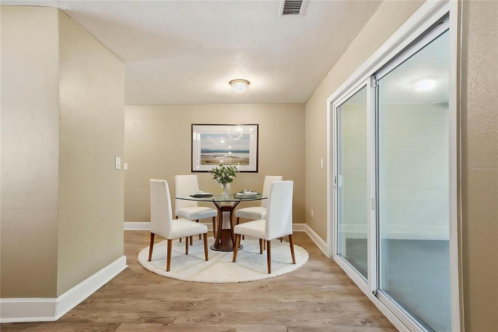 A dining area features a glass table, four white chairs, and a sliding glass door — 3521 ARCH STREET, ORLANDO, FL