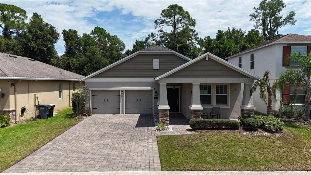 A single-story house with a two-car garage, a covered front porch, and a paved driveway — 383 BRUNSWICK DRIVE, DAVENPORT, FL