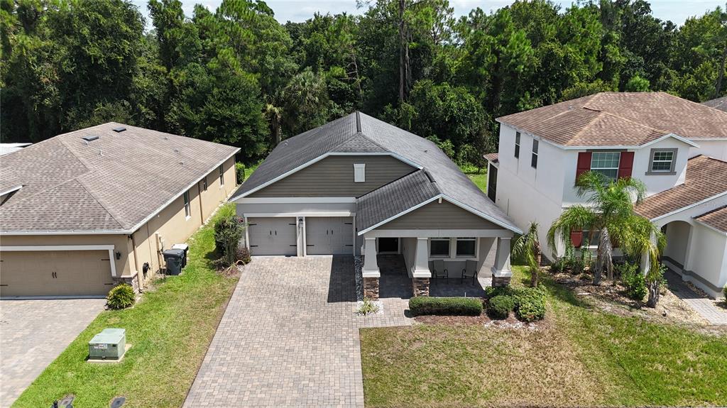 An aerial view shows a single-story house with a paved driveway between two neighboring homes — 383 BRUNSWICK DRIVE, DAVENPORT, FL