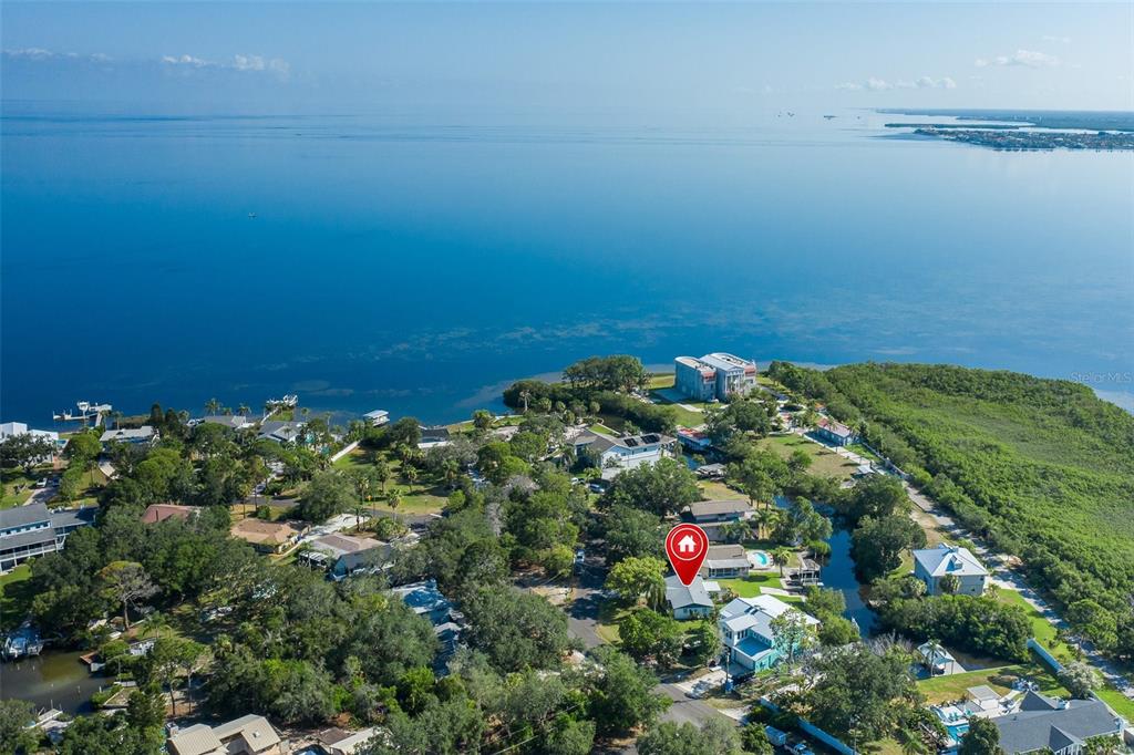 An aerial view shows a residential neighborhood situated along a large body of water — 3318 PINEVIEW DRIVE, HOLIDAY, FL