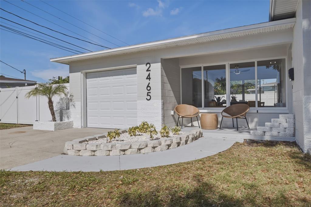 A single-story house exterior features a garage, a front patio with chairs, and landscaping — 2465 38TH STREET N, ST PETERSBURG, FL