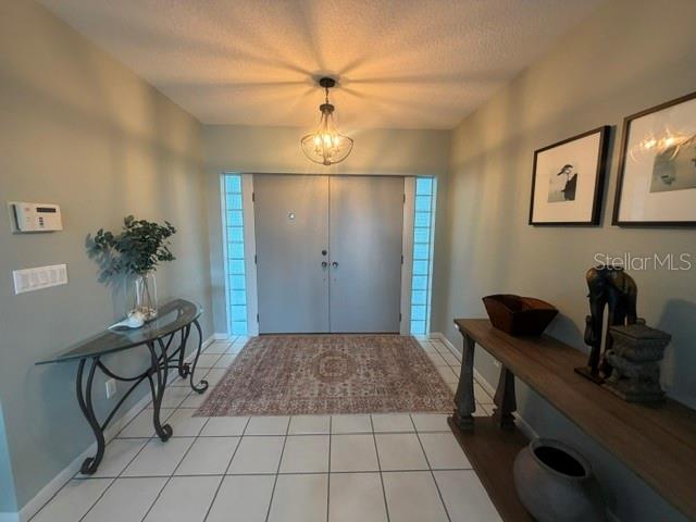 A foyer features a double door entrance, tiled floors, a chandelier, and two console tables — 2241 WINTERSET ROAD, WINTER HAVEN, FL