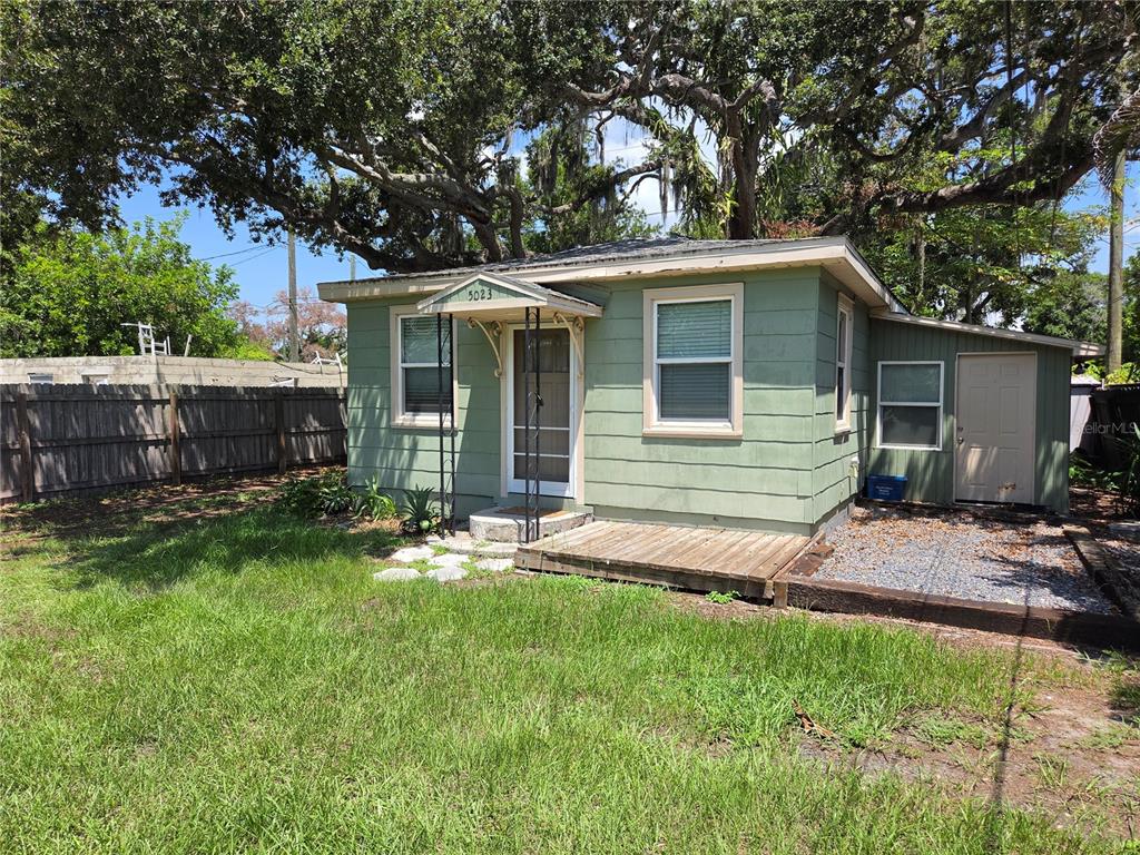 A small, light green house with a wooden deck and a gravel side yard — 5023 27TH AVENUE S, GULFPORT, FL