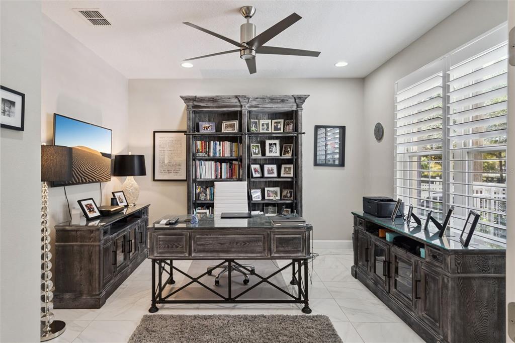 A modern kitchen features light-colored cabinetry, a large central island with bar seating, and tile flooring — 1495 LAKE GEORGE DRIVE, LAKE MARY, FL