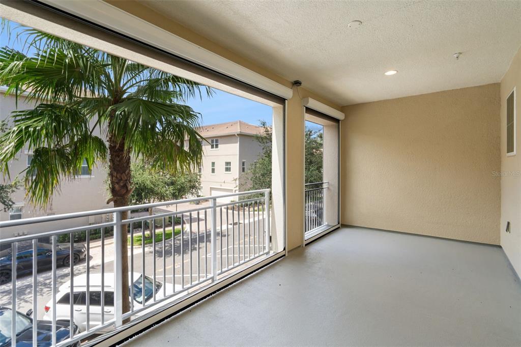 A three-story townhouse exterior features a palm tree, screened balconies, and a white fence — 1495 LAKE GEORGE DRIVE, LAKE MARY, FL