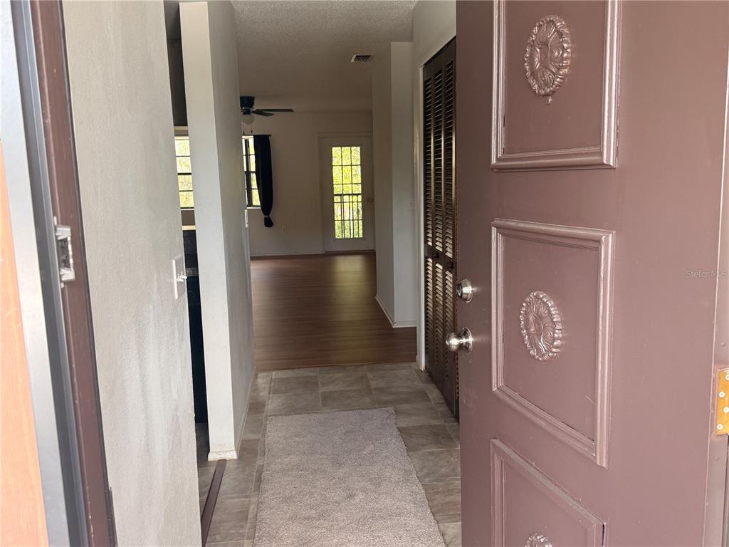 A living and dining room with wood-look flooring, a ceiling fan, and a chandelier — 12155 ENVIRONMENTAL DRIVE UNIT 6, NEW PORT RICHEY, FL