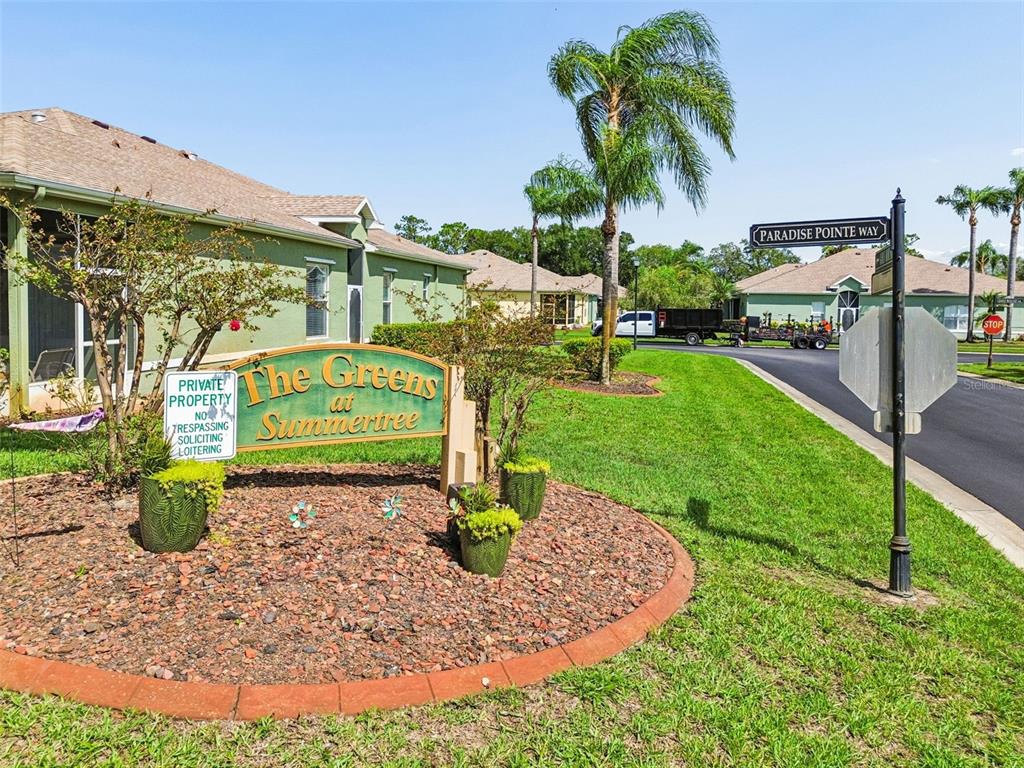 A sign for The Greens at Summertree stands in a landscaped bed near a street — 12154 PUTTER GREEN COURT, NEW PORT RICHEY, FL