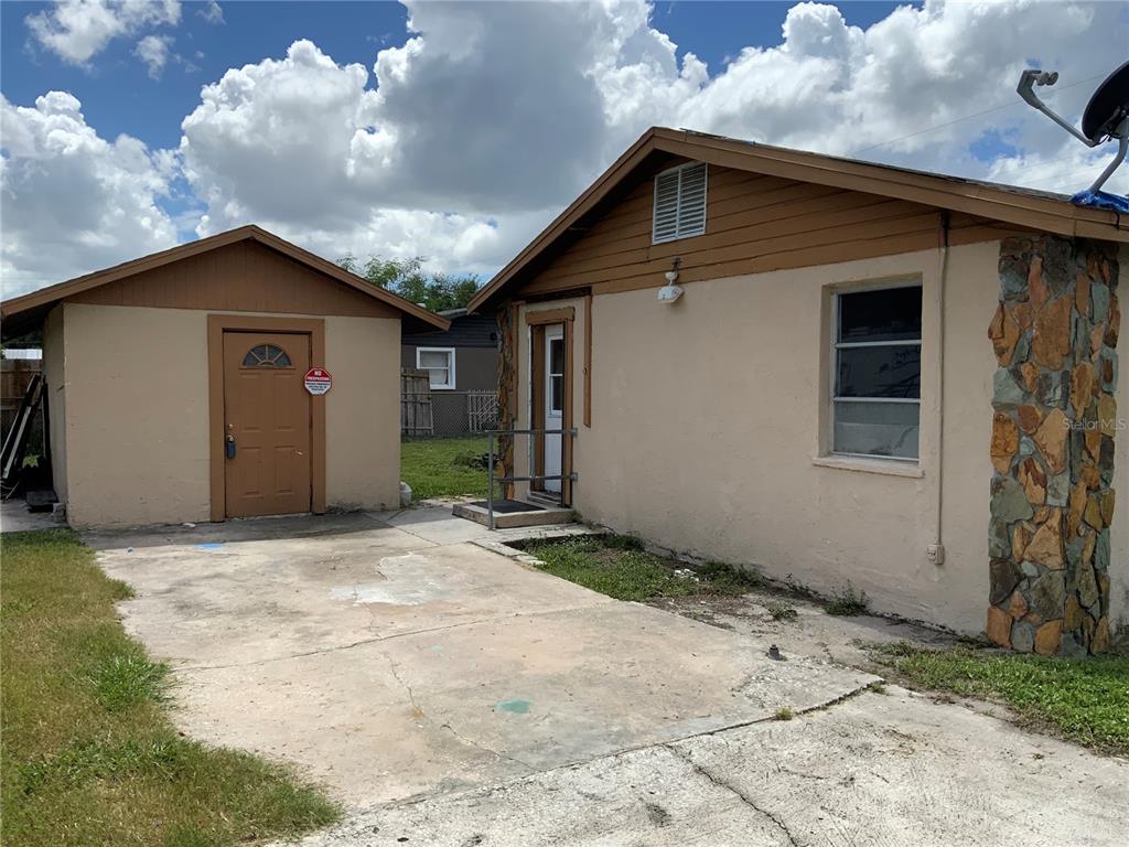 A detached shed and a house with a stone-accented exterior wall and concrete driveway — 2118 1ST AVENUE E, PALMETTO, FL