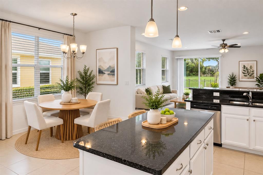 An open-concept living area features a carpeted staircase, tile flooring, and a kitchen breakfast bar — 4240 GUMBO LIMBO DRIVE, ORLANDO, FL