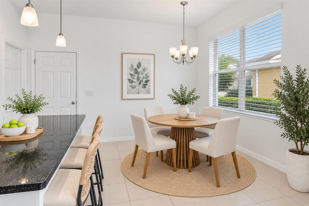 An open-concept living area with tile flooring, a kitchen with white cabinets, and a staircase — 4240 GUMBO LIMBO DRIVE, ORLANDO, FL